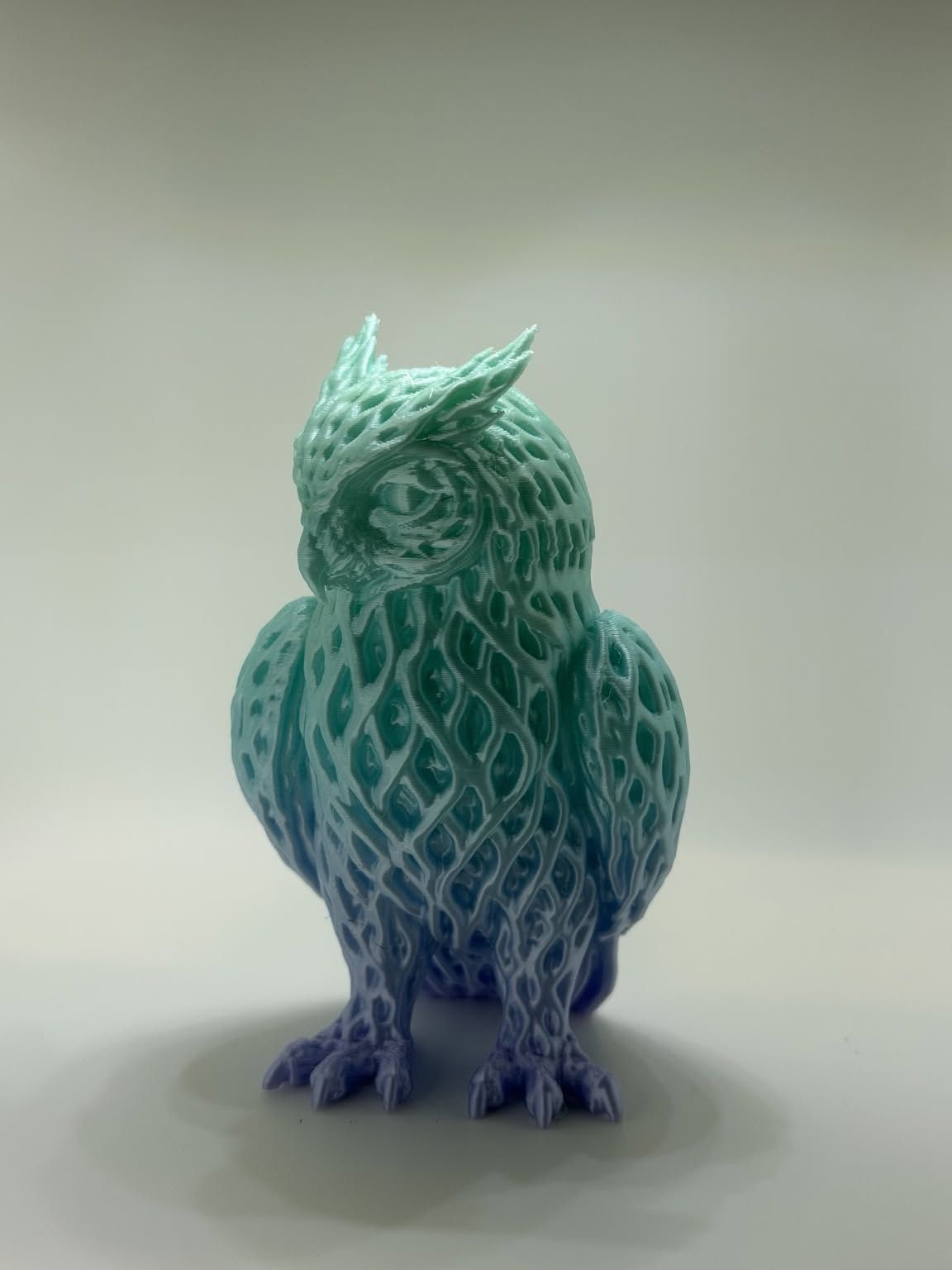 Owl figure with a lattice-textured surface, printed in filament that shifts from teal to blue and purple